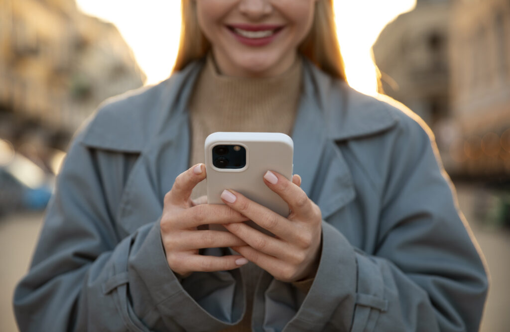 Close-up of a woman smiling and holding a phone