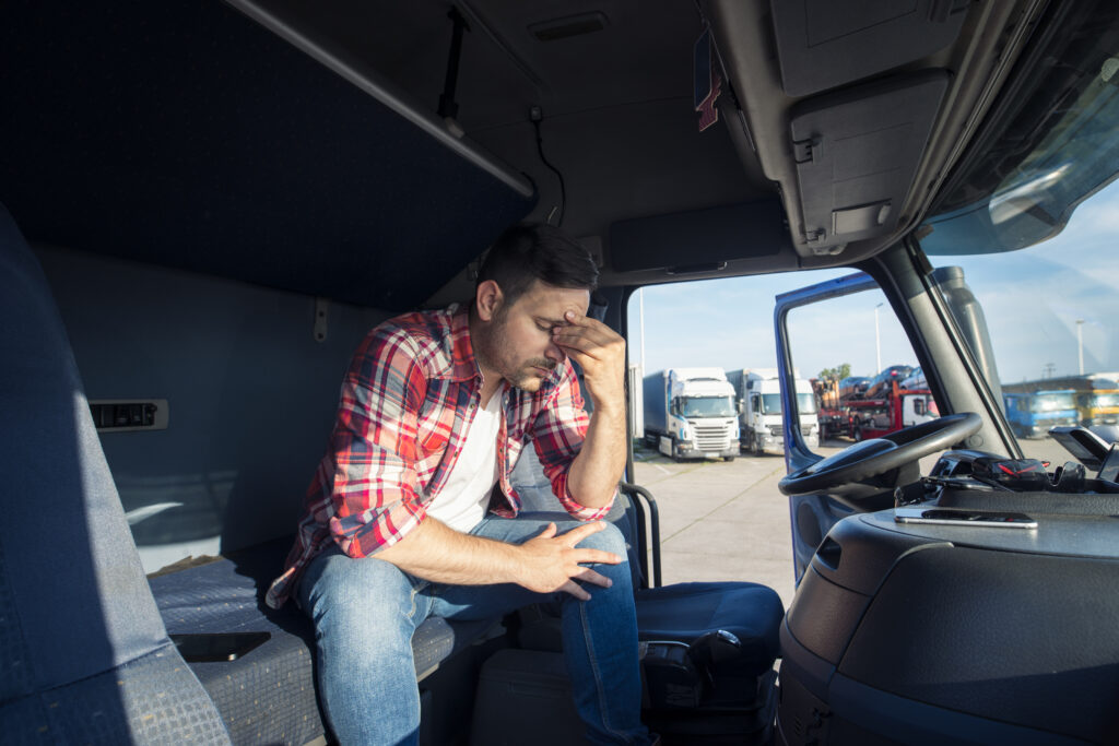 Truck driving sitting in his truck worried