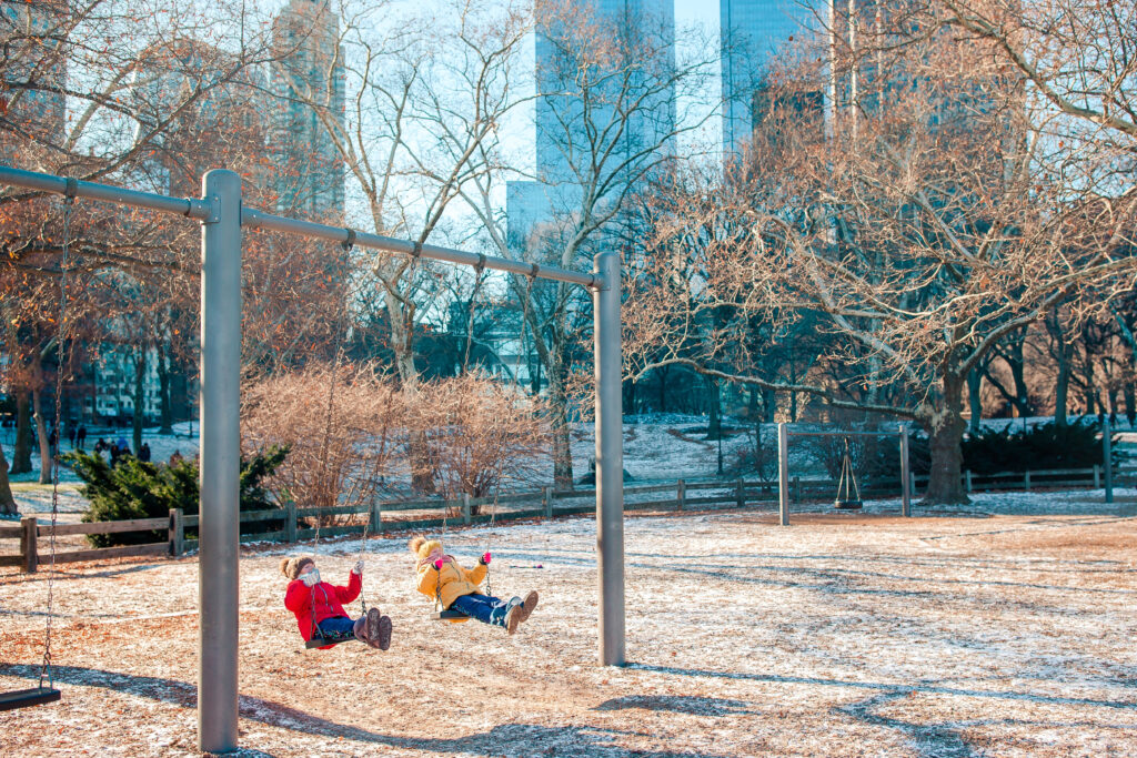 Two kids on swings in Central Park