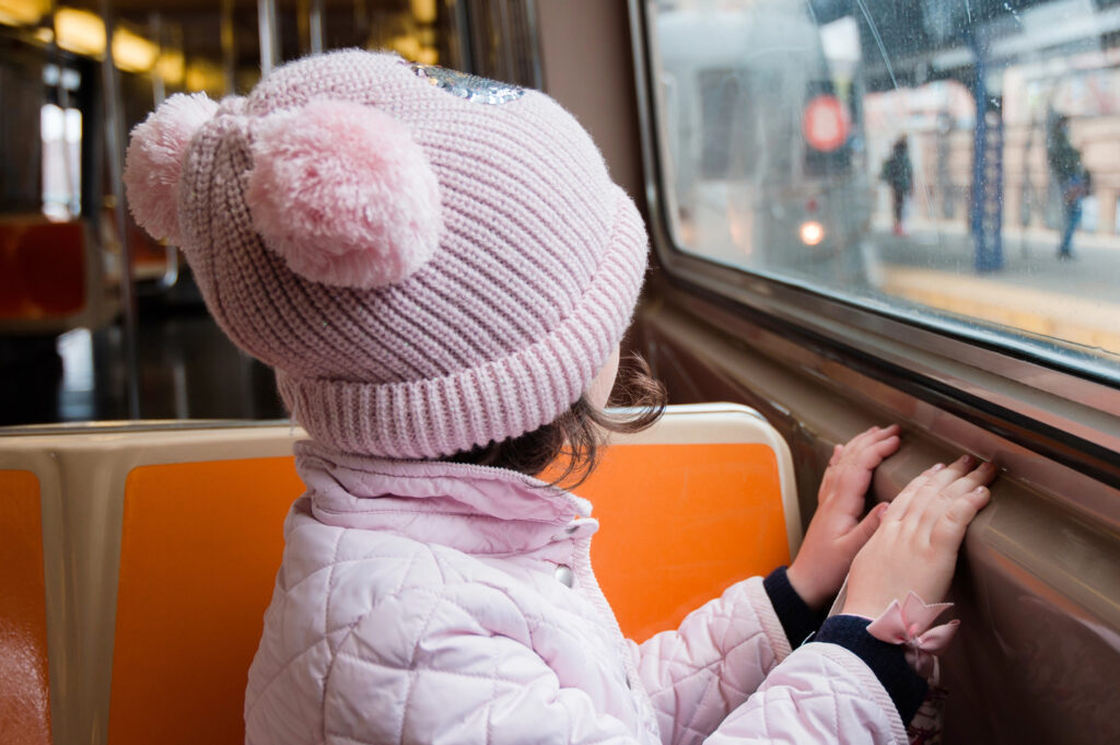 Little girl wearing pink on the NYC subway