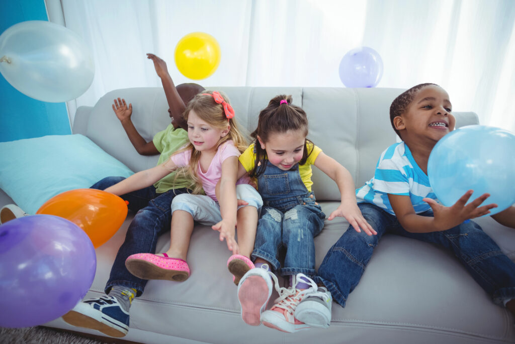 Kids playing with balloons in a living room