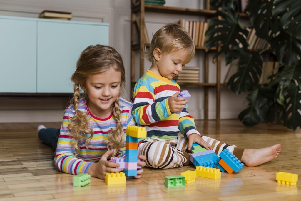 Siblings playing together with lego blocks