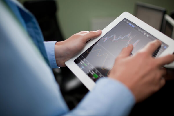 Anon person looking at stock charts on a tablet computer
