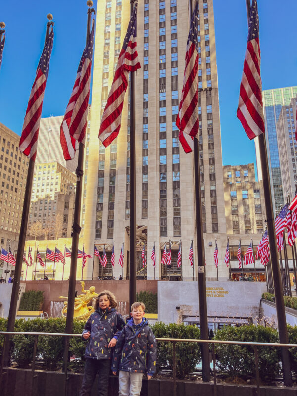 Two boys standing outside the Rockefeller Center in New York