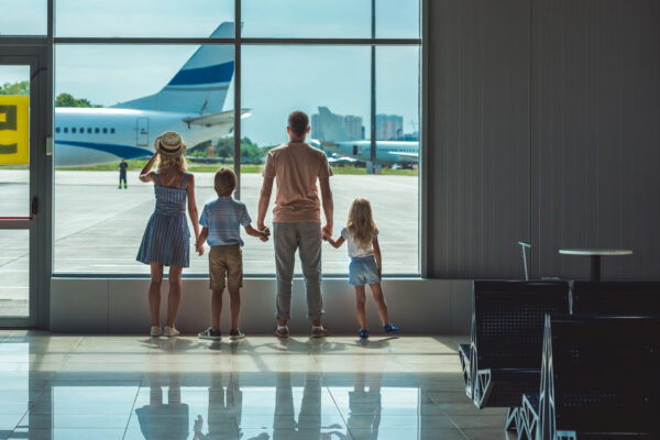 Family of four looking out the window of an airport
