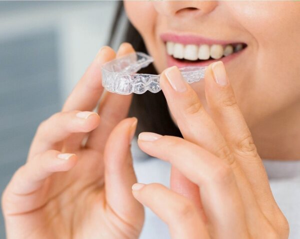 Anon woman holding a dental retainer