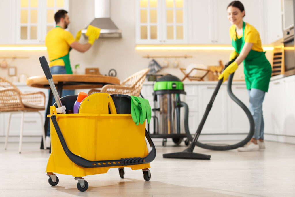 Professional cleaners cleaning a kitchen in a domestic home