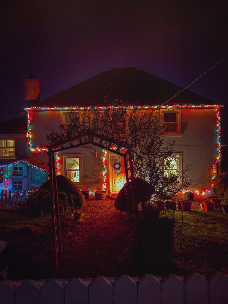 Cottage farmhouse decorated with multi-colored Christmas lights